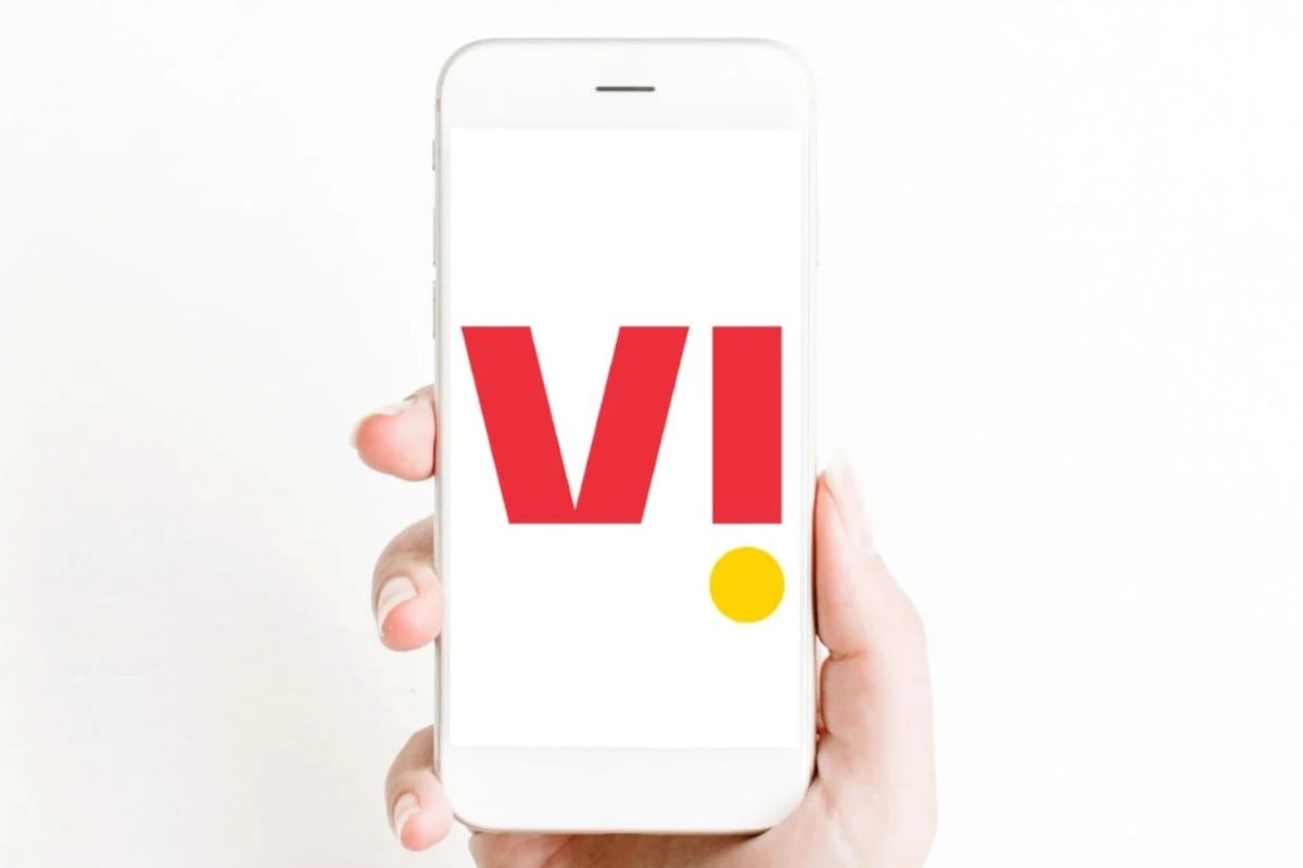 Hand holding smartphone with red letter logo.