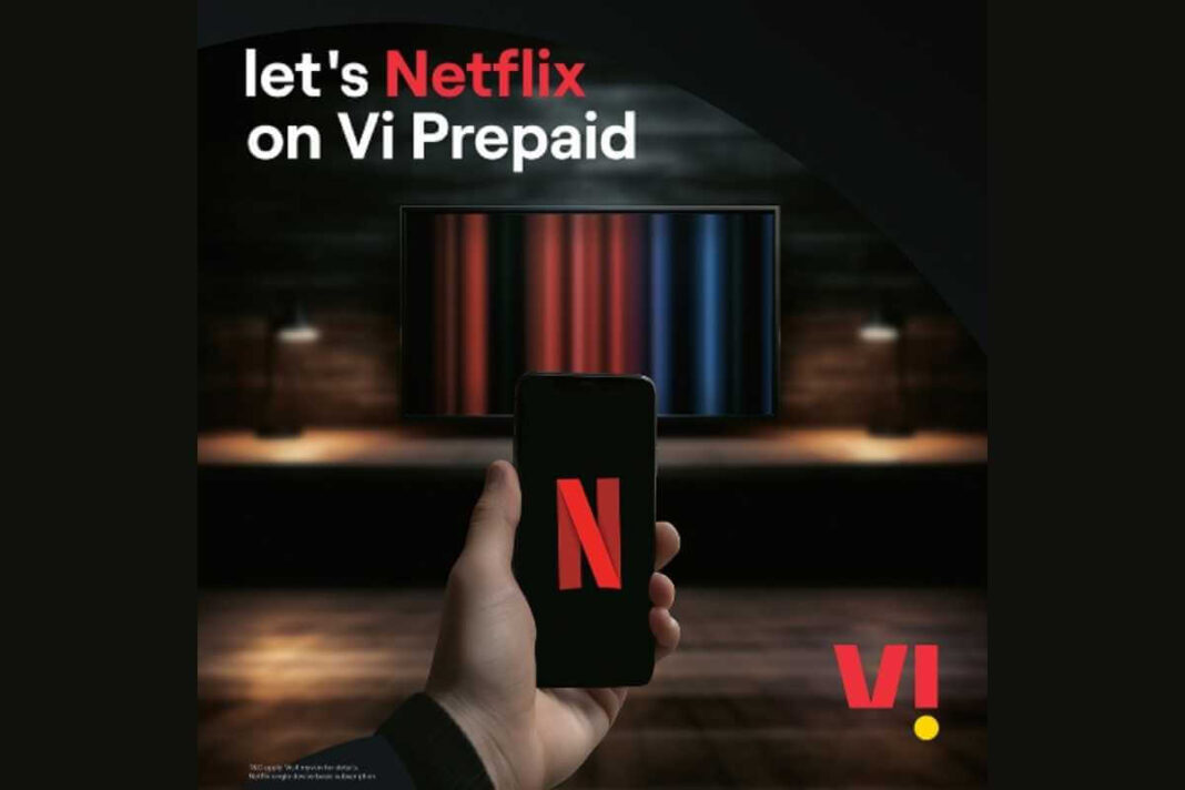 Hand holding phone with Netflix, TV in background.