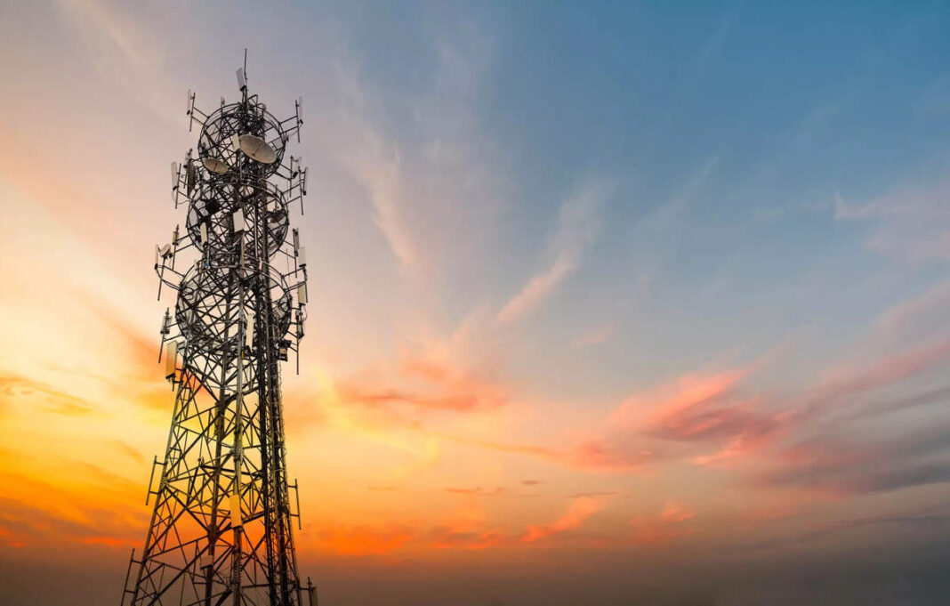 Communication tower at sunset with colorful sky.