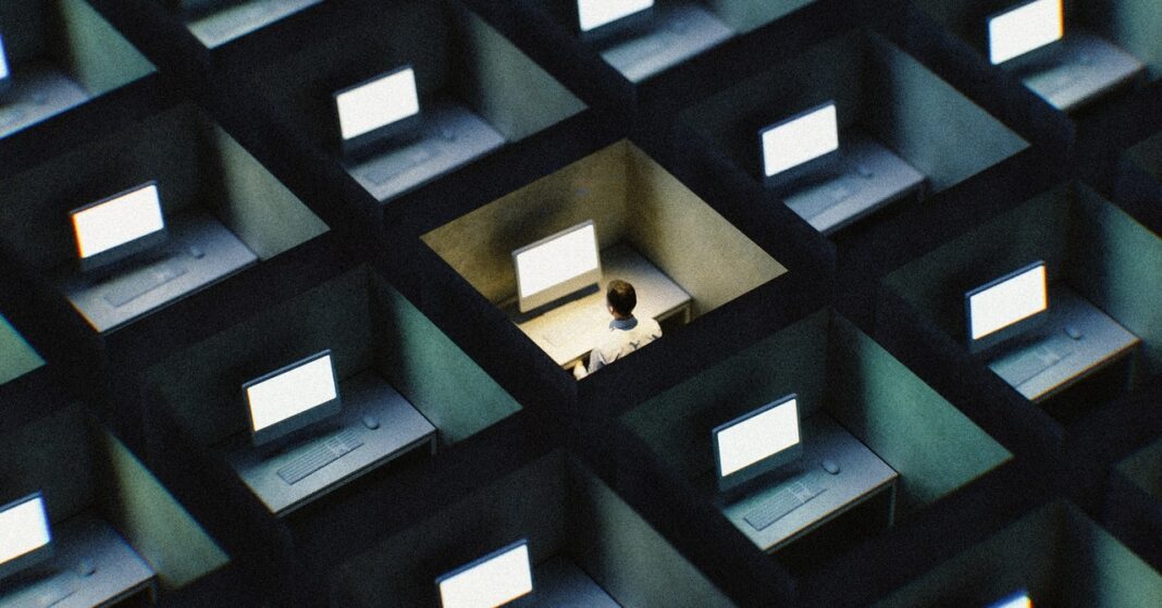 Person in a cubicle maze with computers.