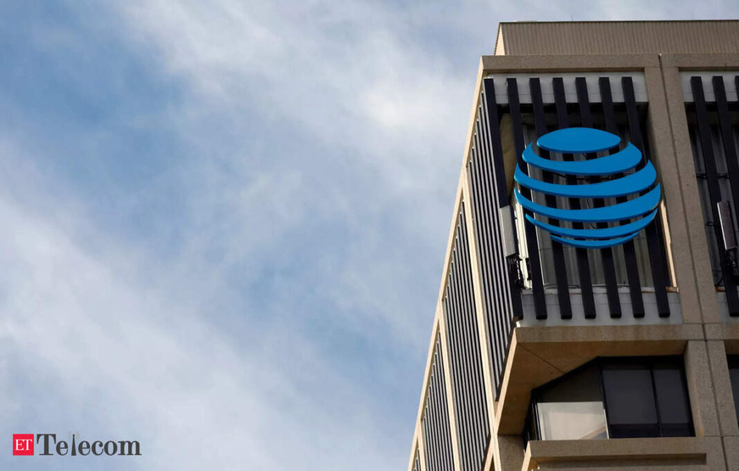 Building with blue sphere logo against cloudy sky.