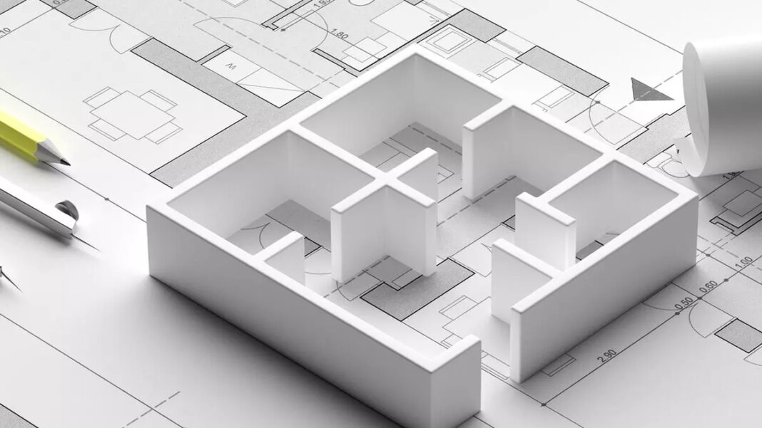 Architectural model on blueprint with pen and ruler.