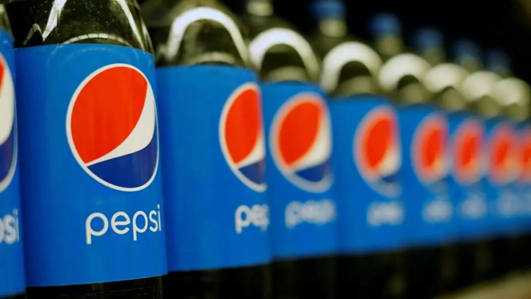 Row of Pepsi bottles on shelf.
