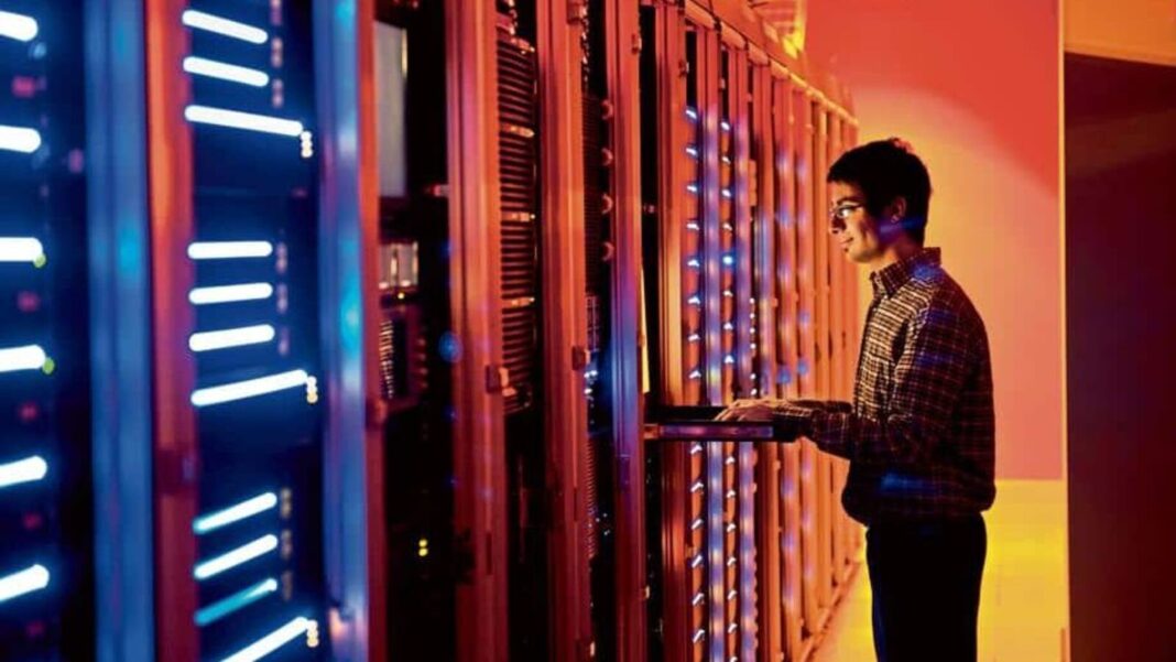 Technician working in server room at data center.