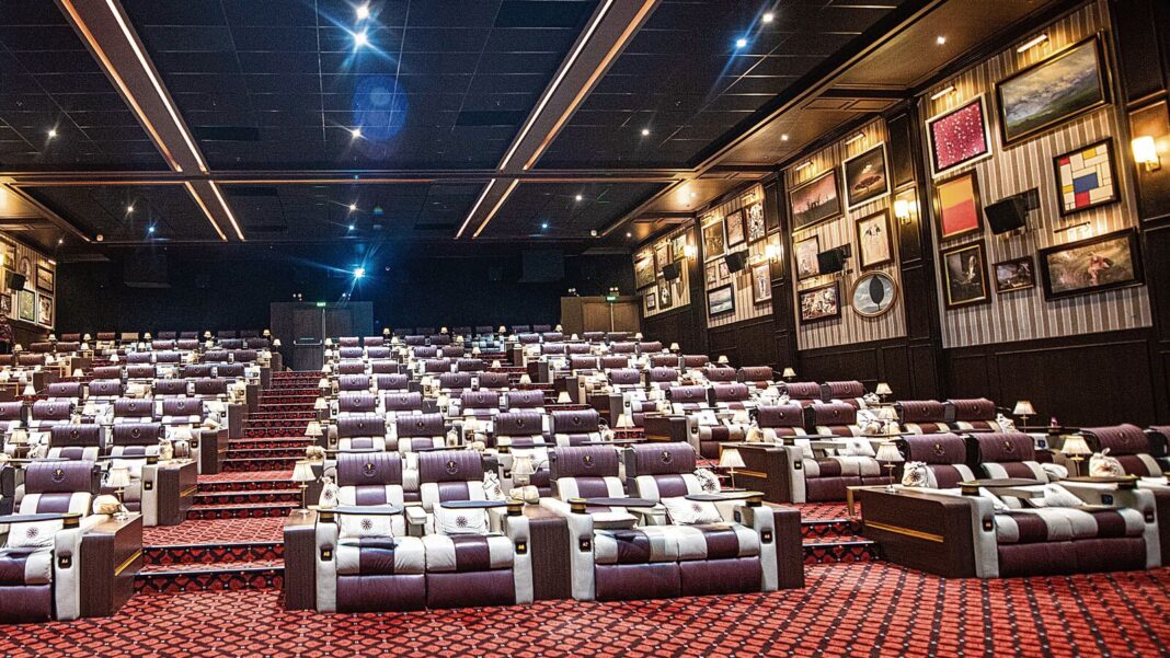 Luxury movie theater interior with comfortable seats and decor.