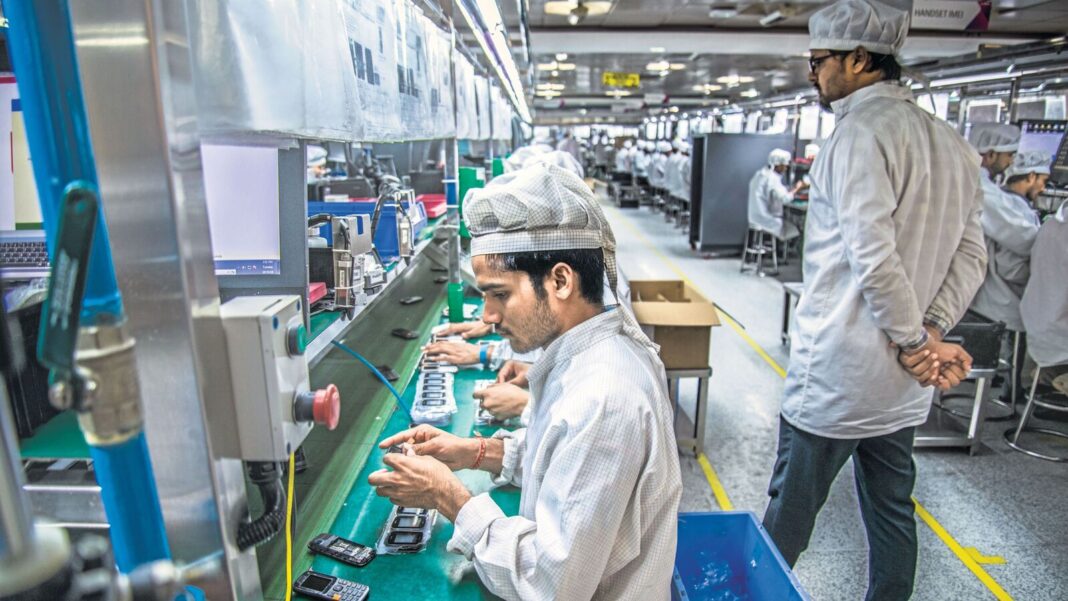 Workers assembling electronics on a factory line.