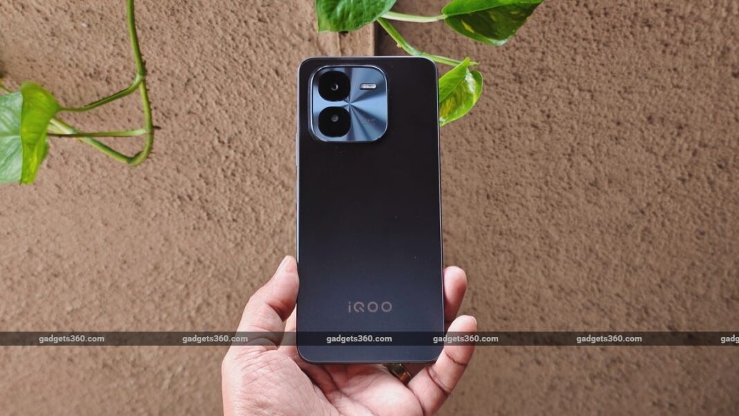 Hand holding new iQOO smartphone with camera close-up.