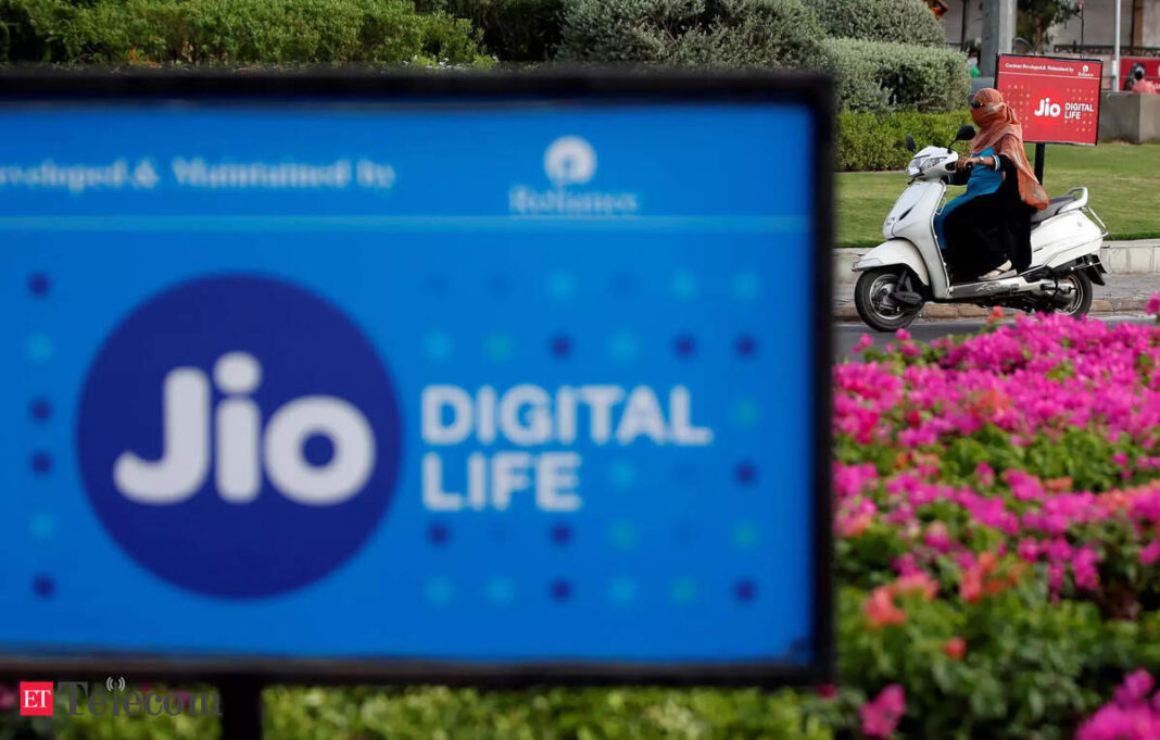 Person riding scooter behind Jio Digital Life advertisement.