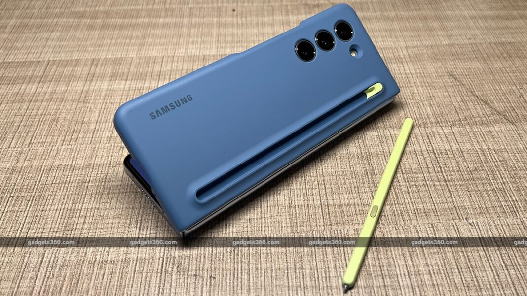 Blue Samsung smartphone and yellow stylus on fabric.