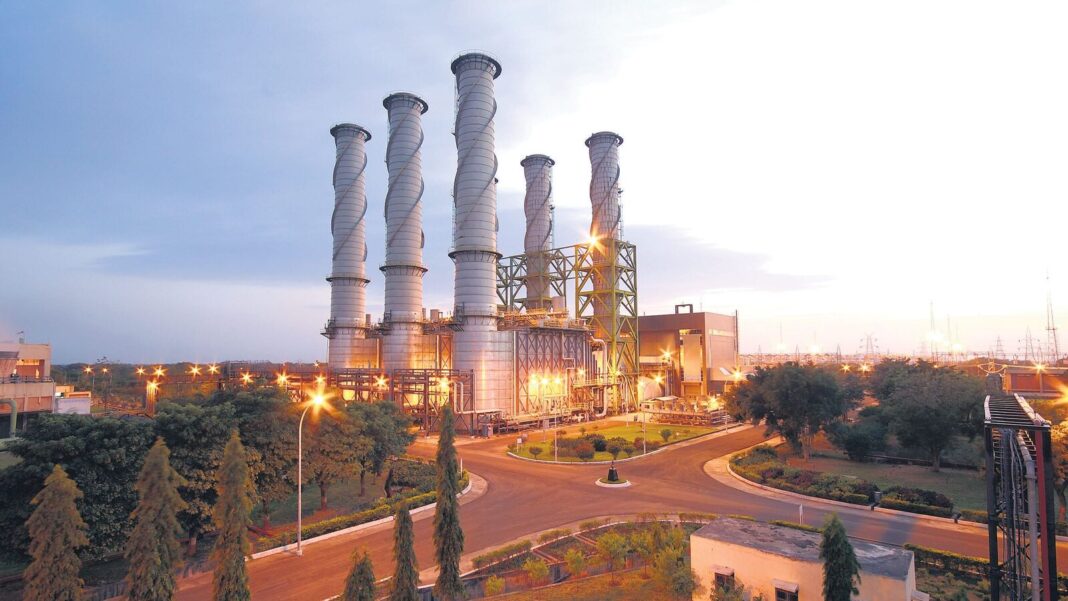 Industrial power plant at dusk with illuminated lights