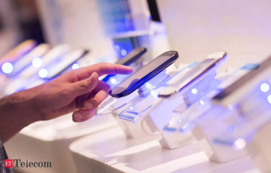 Person examining smartphones on display.