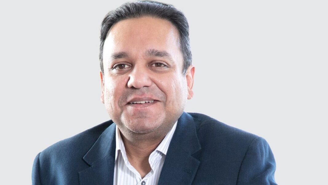 Smiling businessman in navy suit against white background.