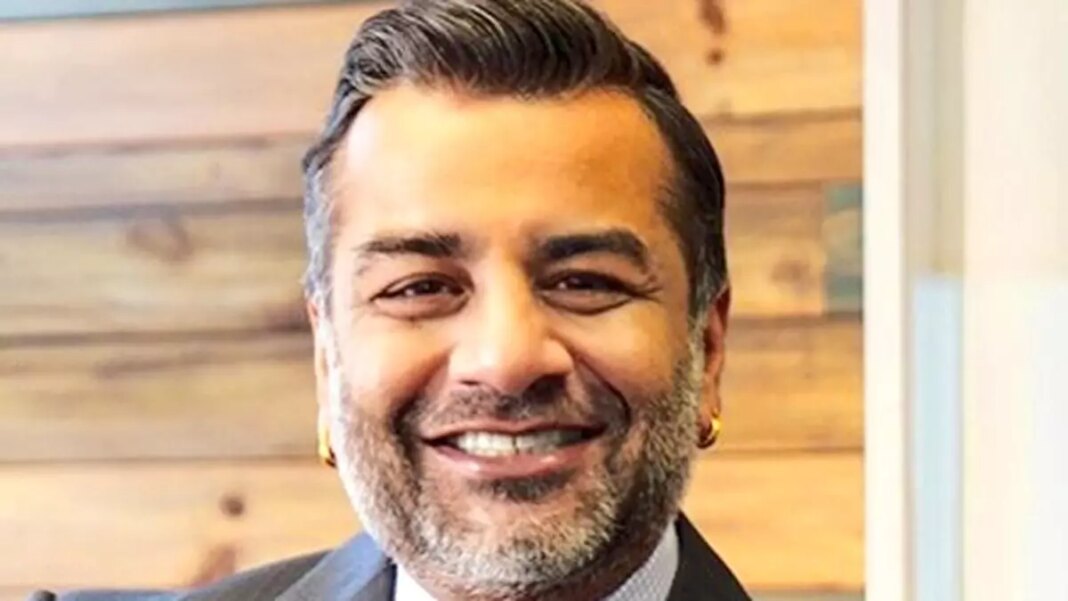 Smiling businessman in front of wood panel background.