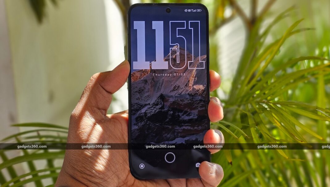 Smartphone with clock wallpaper held outdoors.