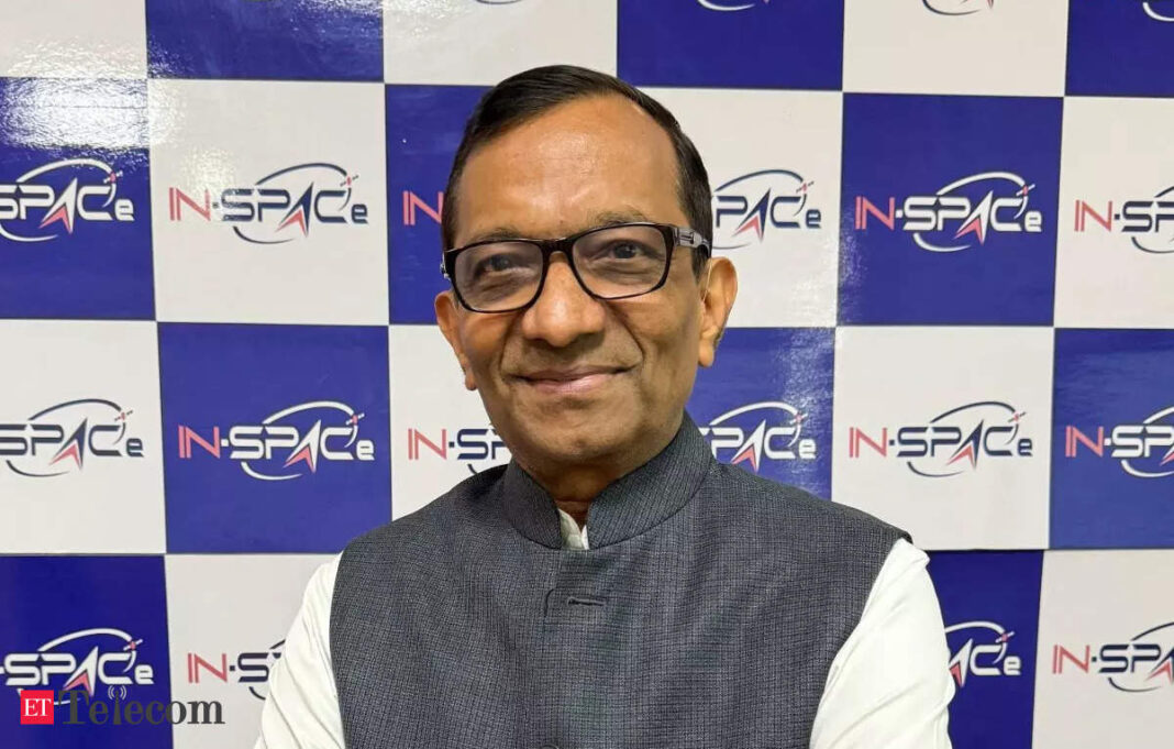 Man in glasses smiling against IN-SPACe backdrop.