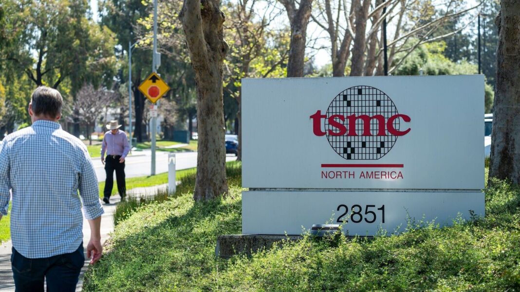 TSMC North America sign with pedestrians nearby.