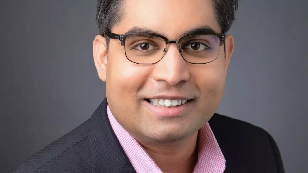 Smiling man in suit with glasses for professional headshot.