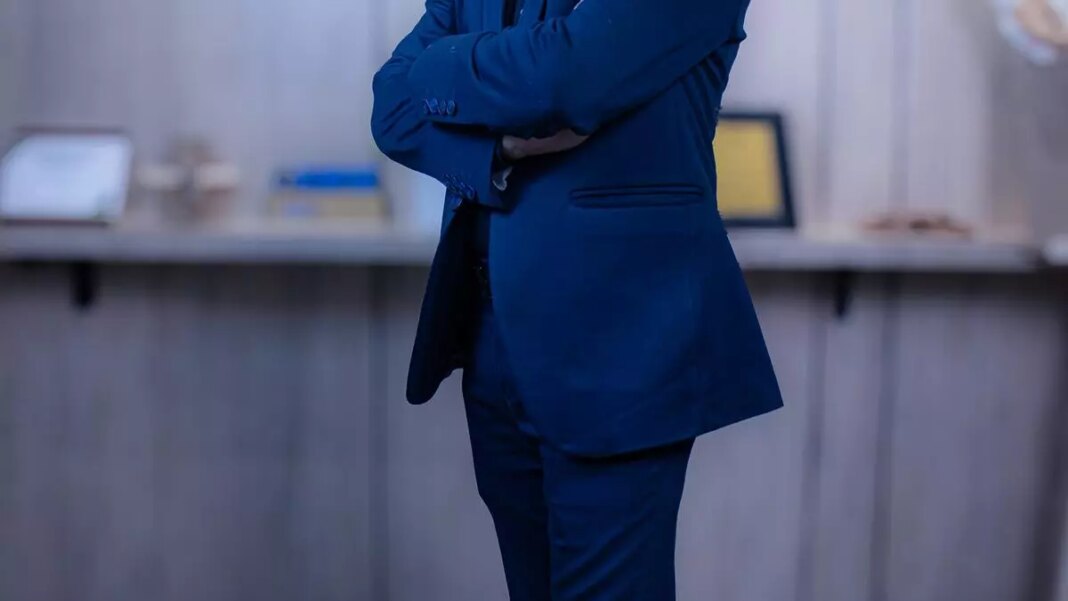 Person in blue suit with arms crossed.