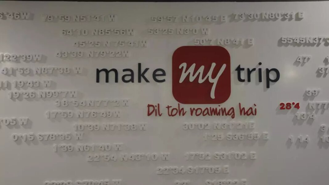 MakeMyTrip logo with slogan on textured wall