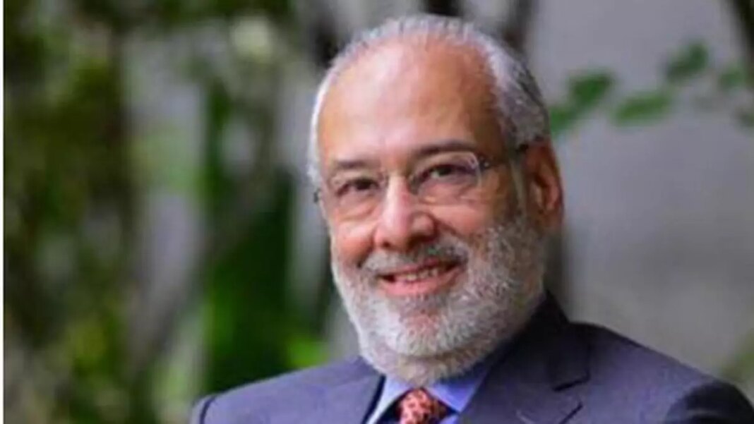 Smiling man with beard, suit, and tie outdoors.