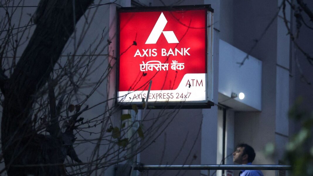 Illuminated Axis Bank ATM sign at dusk.