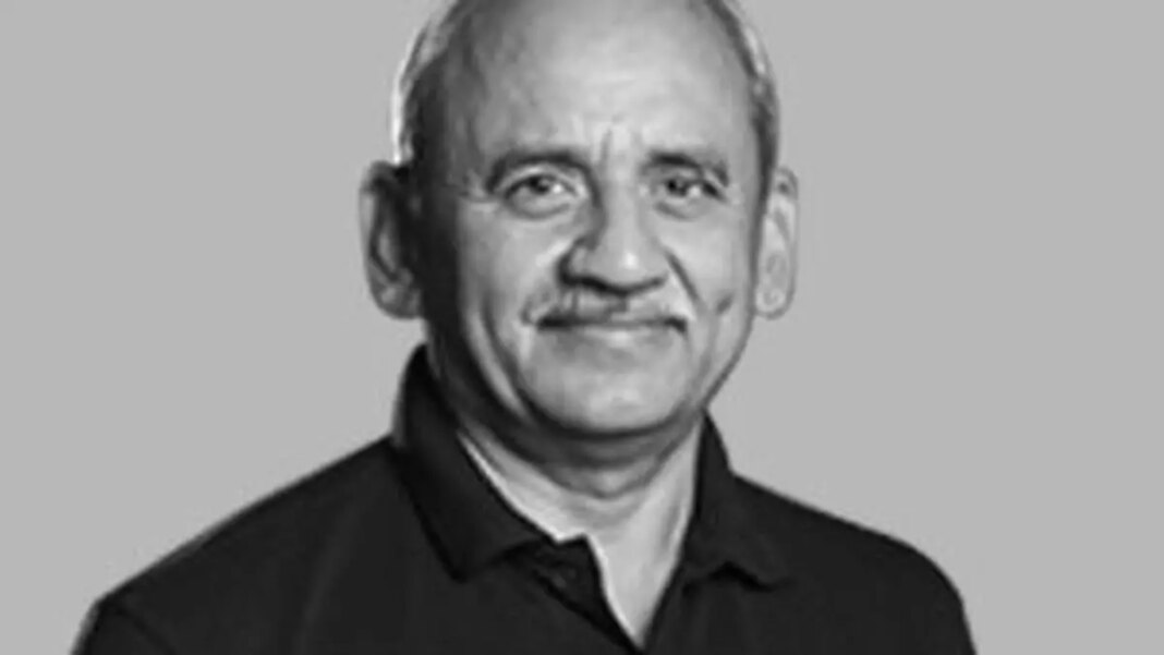 Smiling man in black shirt, black and white photo.