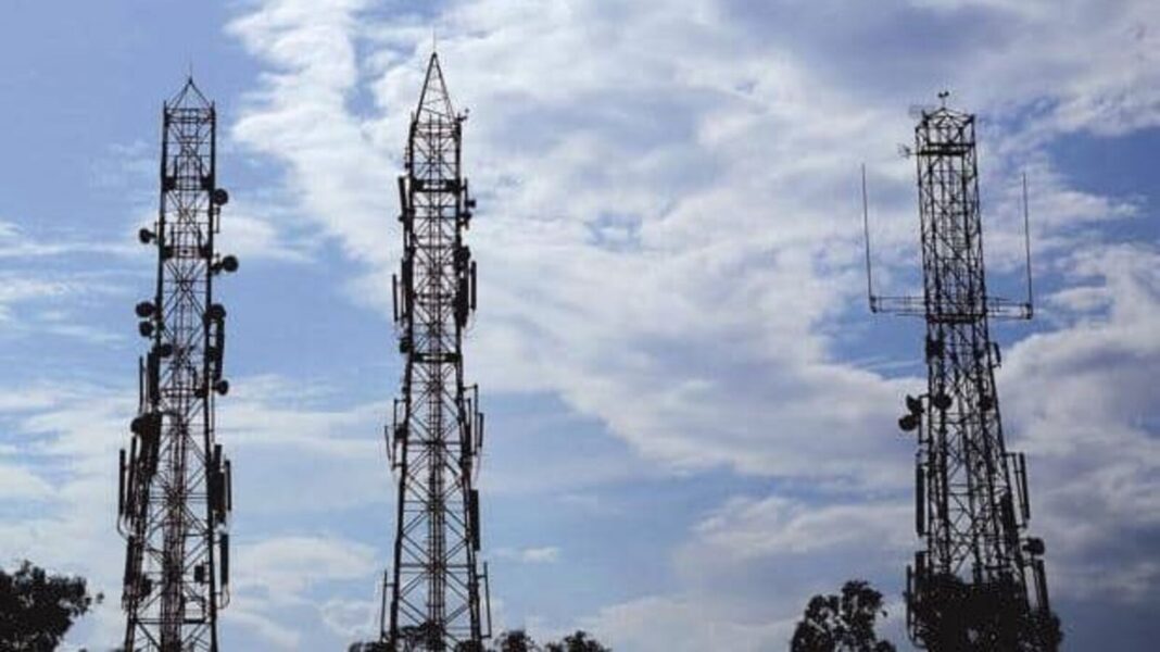 Telecommunication towers against cloudy sky