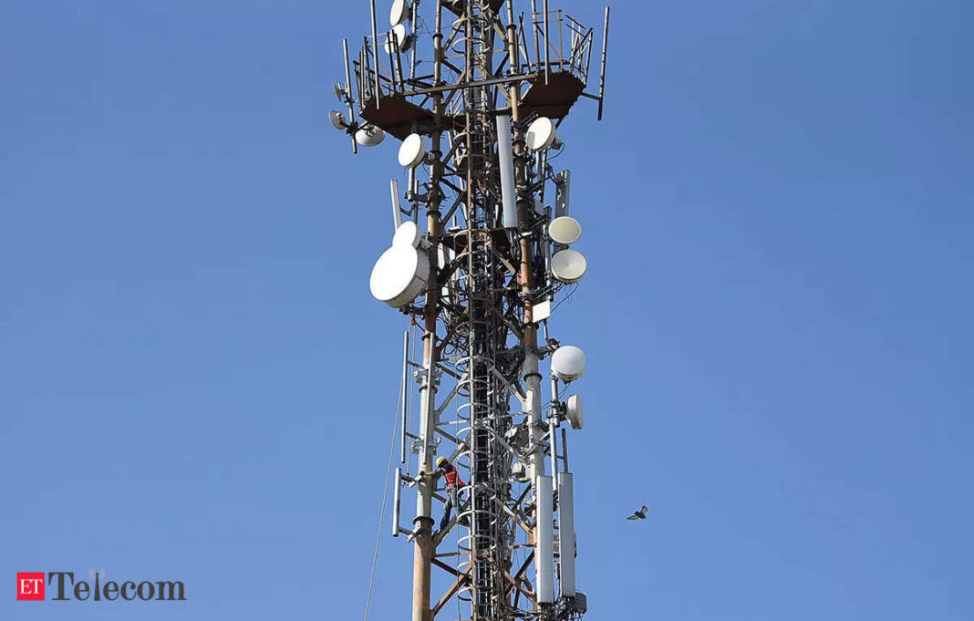 Technician climbing cellular network tower with antennas.