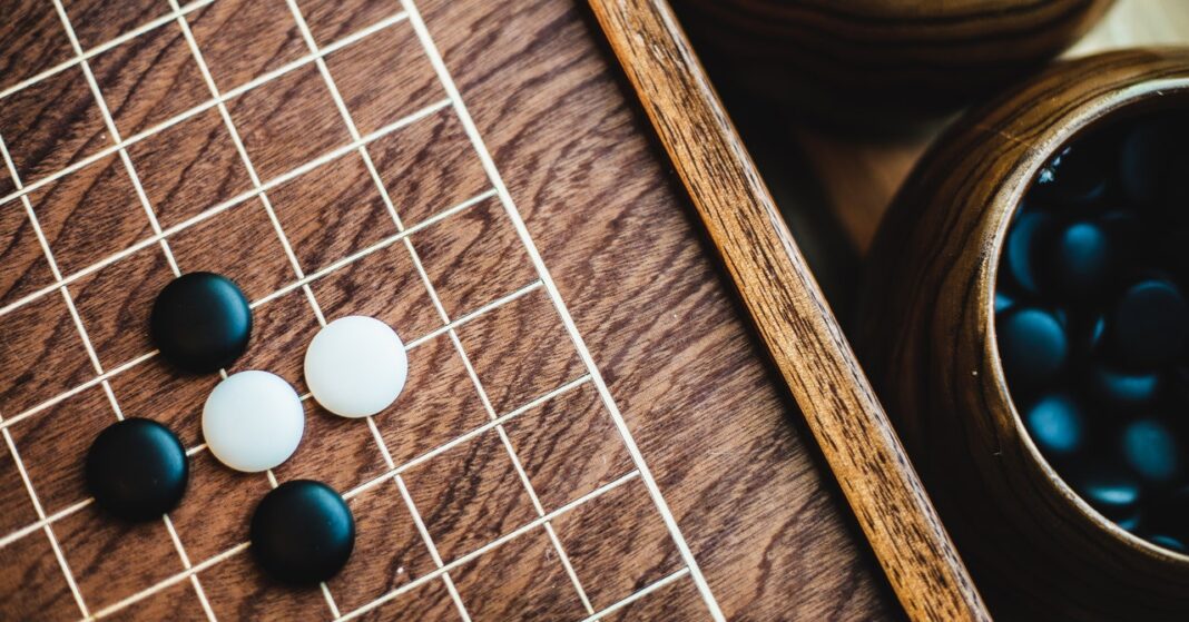 Go stones on wooden board game.