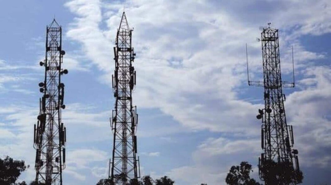 Cell phone towers against cloudy sky.