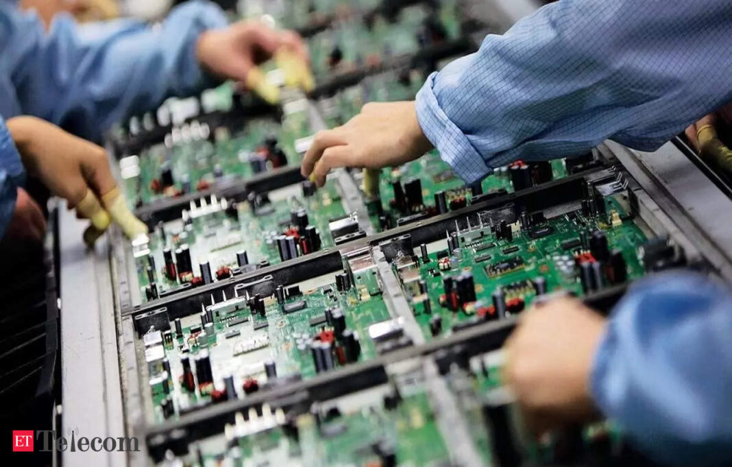 Workers assembling circuit boards in factory.