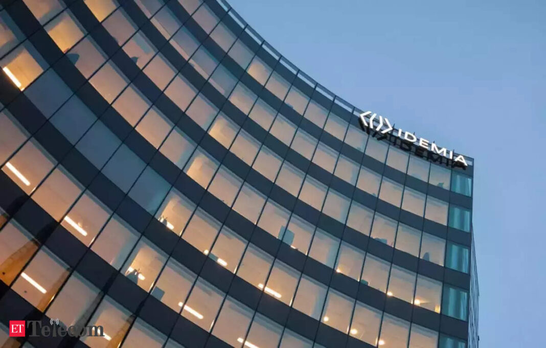Modern office building facade with illuminated company logo at dusk.