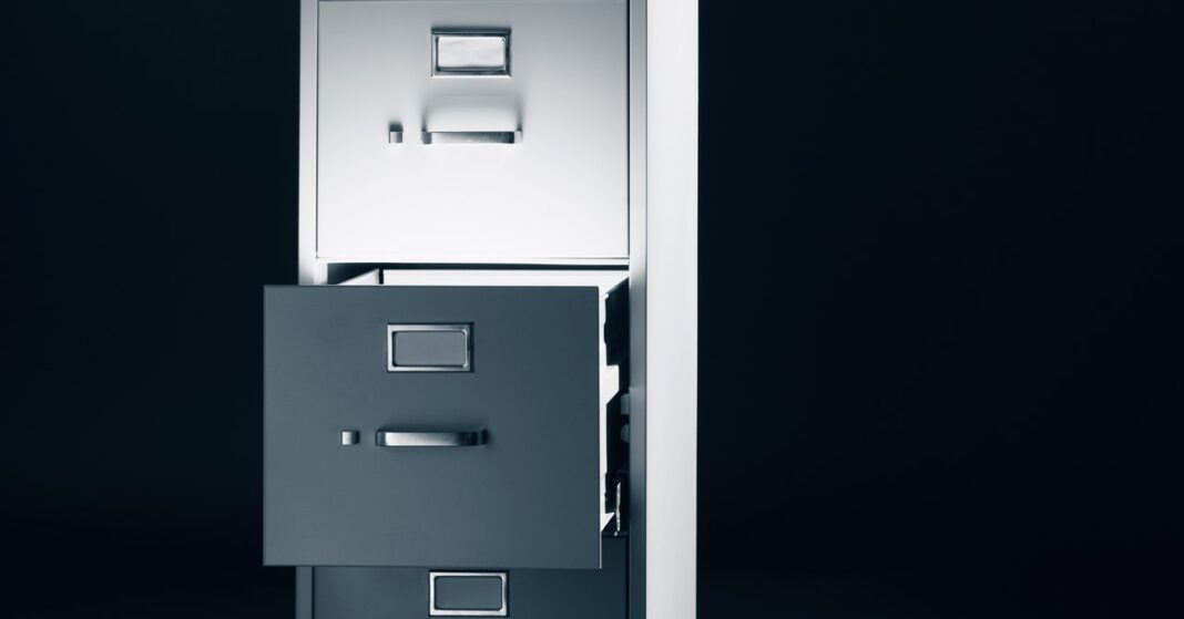 Open file cabinet drawers on dark background.