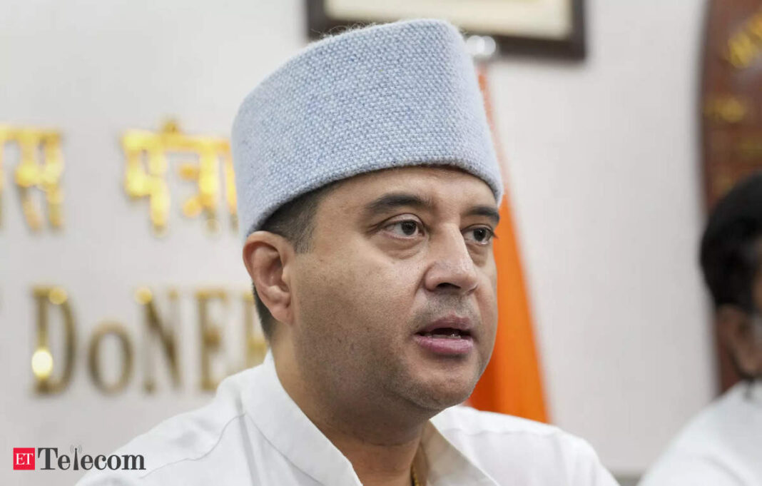 Man speaking at an event in traditional cap.