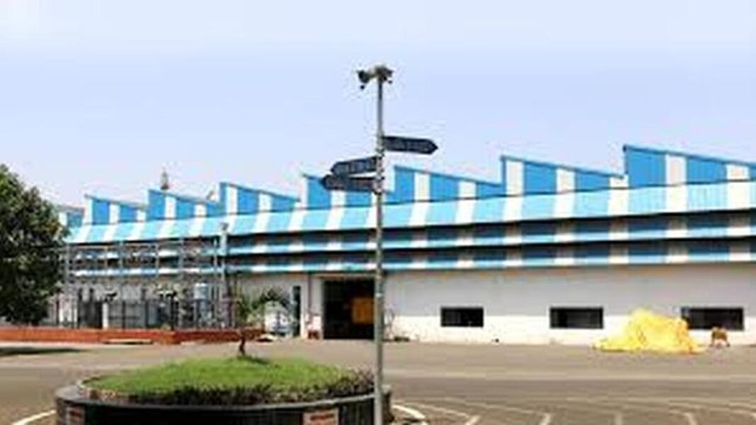 Modern blue-striped industrial building with parking lot.