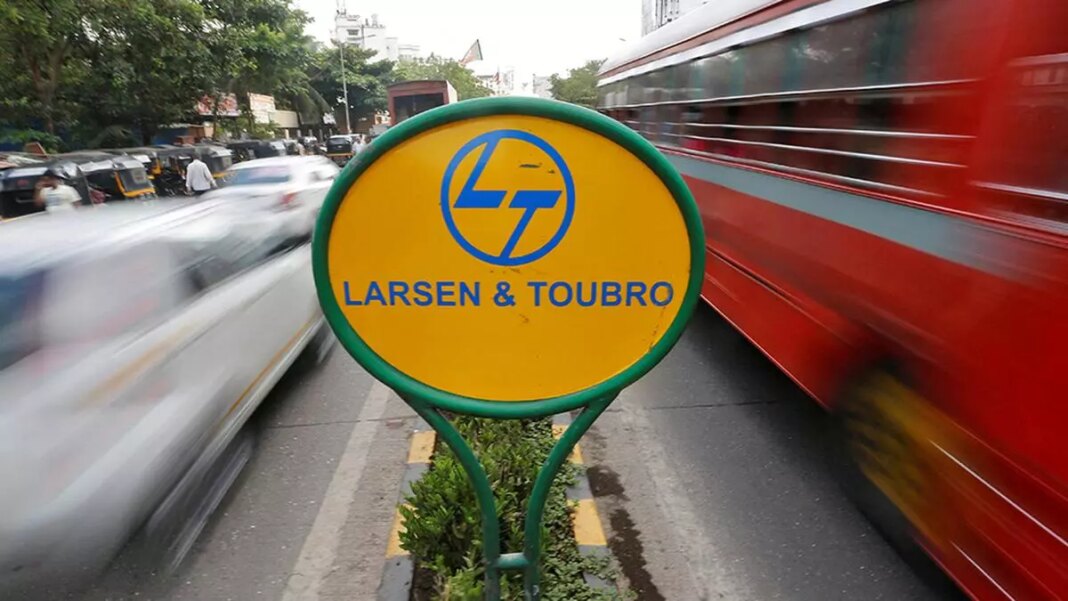 Larsen & Toubro sign with blurred traffic background.