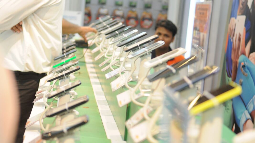 Smartphones displayed at a tech store counter.