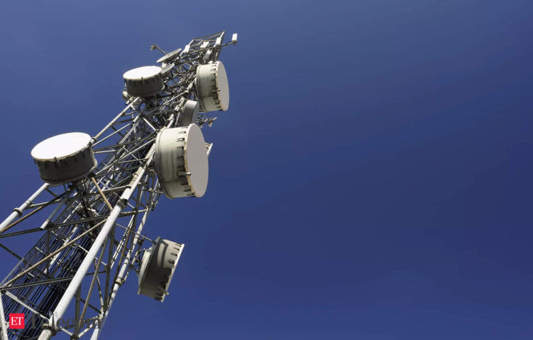 Cellular tower with antennas against blue sky.