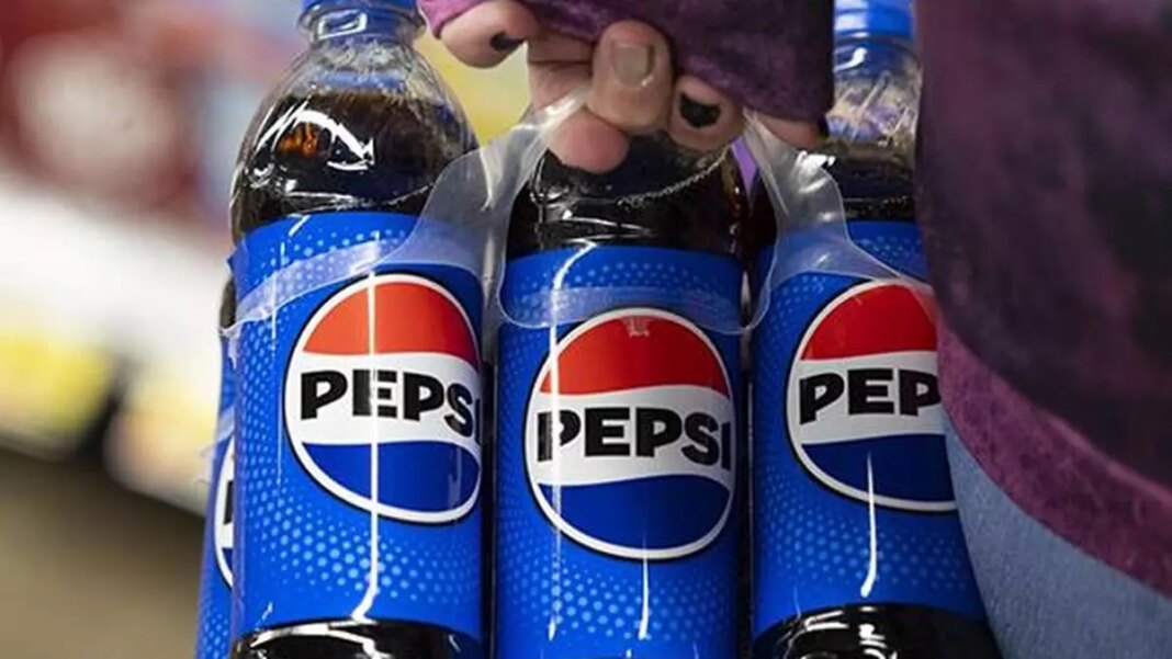 Person holding three Pepsi bottles.