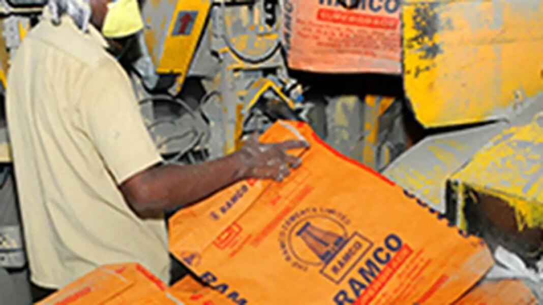 Worker handling cement bags at construction site.