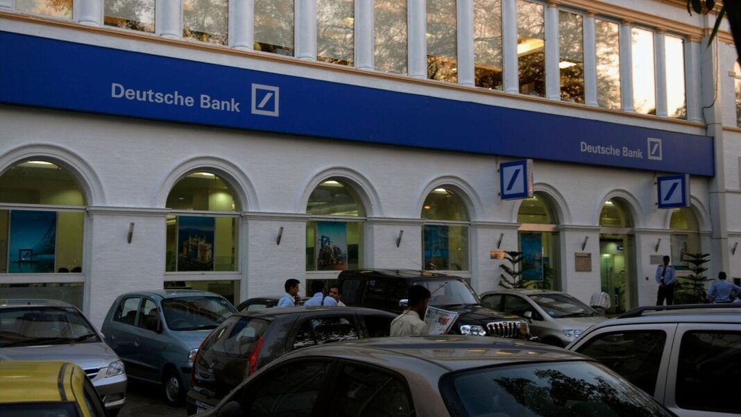 Deutsche Bank branch exterior with cars and pedestrians.