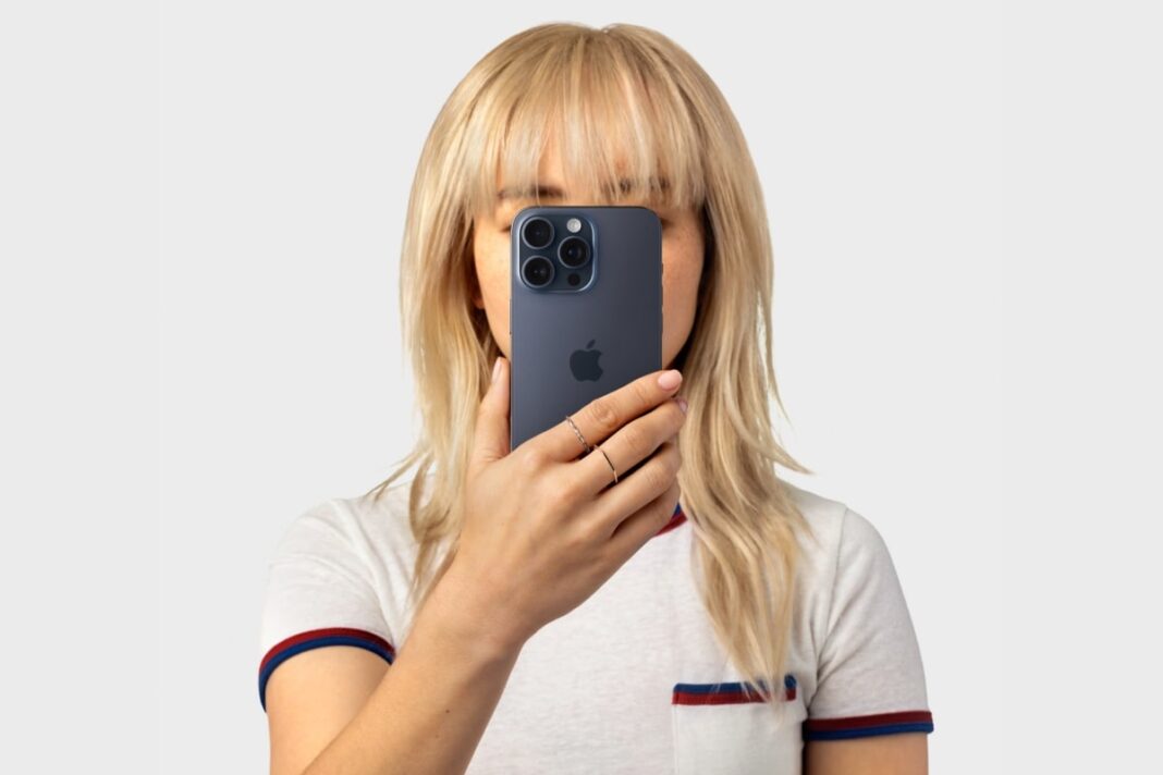 Woman covering face with smartphone