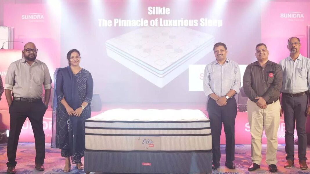 Team presenting luxury mattress at promotional event.
