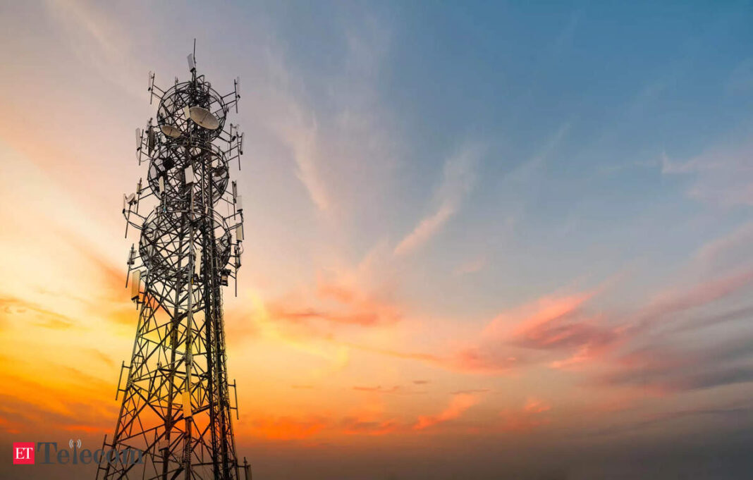 Cell tower silhouette against sunset sky.