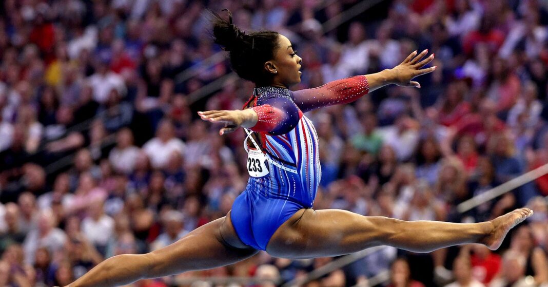 Gymnast mid-air during artistic gymnastic event.