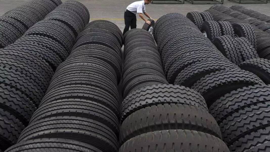 Man inspecting stacks of new tires.