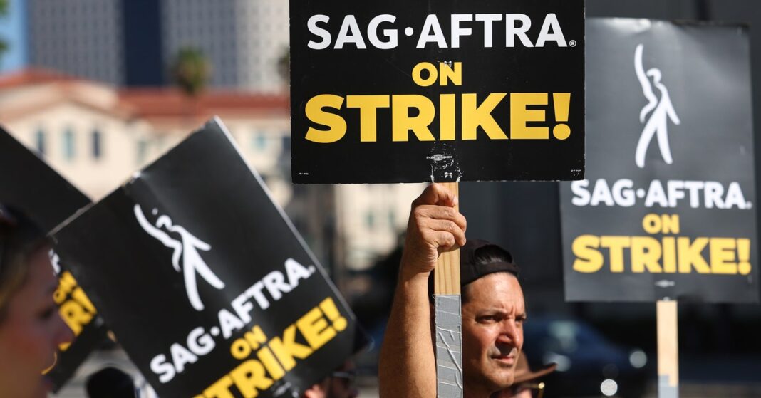 Protestors holding SAG-AFTRA strike signs.