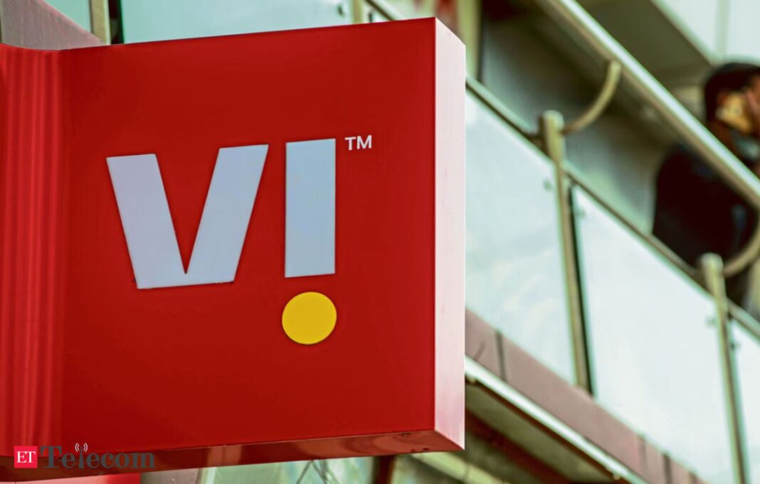 VI logo signage with person talking on phone in background.