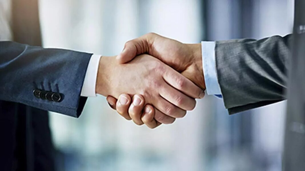 Business professionals shaking hands agreement.