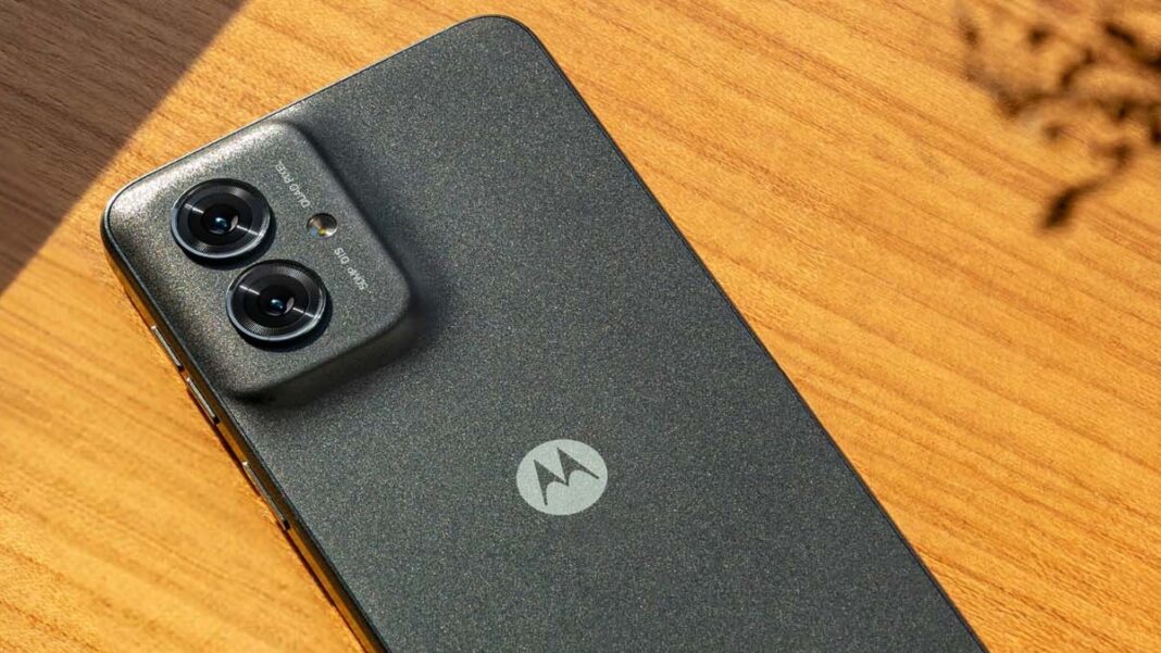 Motorola smartphone with dual cameras on wood surface.